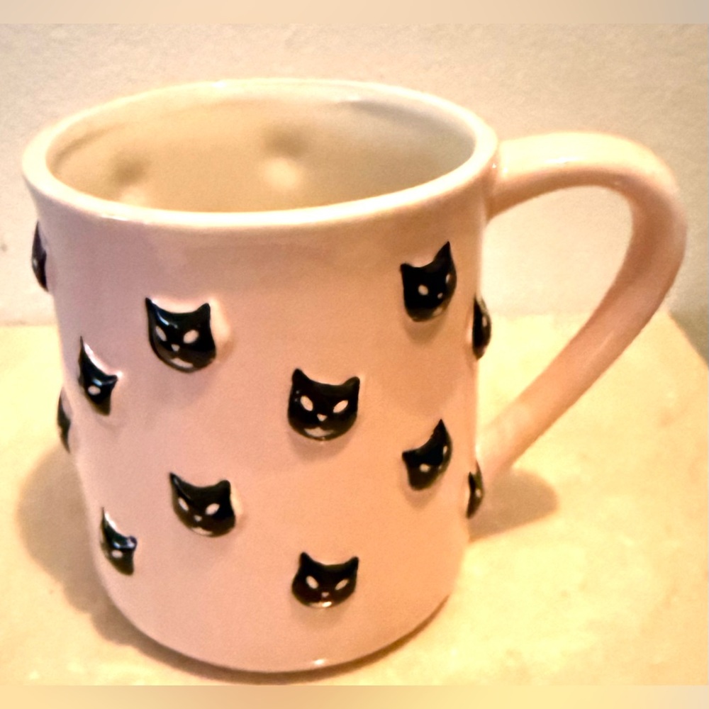 Cobwebs and Cauldrons pink mug with black cat faces embossed on it. 18-20oz